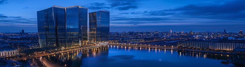 Panoramic view across the Frankfurt skyline at dawn with the twin towers of the ECB Eurotower in the foreground and the Commerzbank Tower beyond, low mist over the river Main, golden sunrise light reflecting off curtain-wall glass, no people no faces no hands