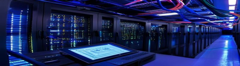 Panoramic view inside an enterprise server room with rows of dark cabinets and softly glowing blue LED status lights along the racks, network cables organised in coloured bundles overhead, a tablet with a software-bill-of-materials diagram resting on a console in the foreground, no people no faces no hands